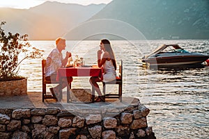 Couple in love drinking wine on romantic dinner at sunset on the beach.