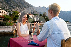 Couple in love drinking wine on romantic dinner at sunset on the beach.