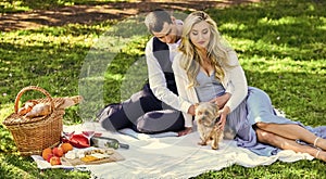 Couple in love enjoy picnic time. Spring date. Playful couple having picnic in park. Couple cuddling relaxing at green