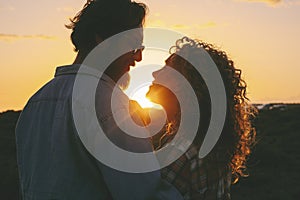 Couple in love enjoy relationship in outdoor leisure activity enjoying a beautiful sunset together looking on eyes and smiling.