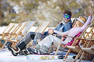 Couple enjoy in sun loungers on ski terrain photo