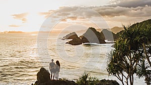 Couple in love enjoying sunset with amazing ocean and mountain view