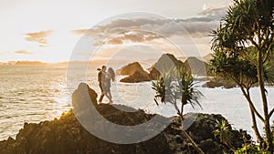 Couple in love enjoying sunset with amazing ocean and mountain view