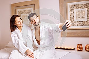 Couple in love enjoying wellness weekend and taking selfies in spa