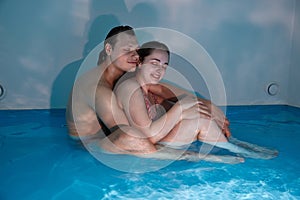 A couple in love enjoys relaxation in a pool with concentrated sea water. Floating for two