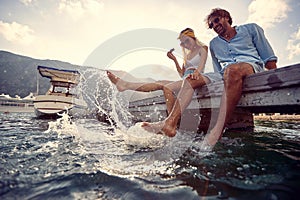 Couple in love flirting and enjoying dangling legs in the lake