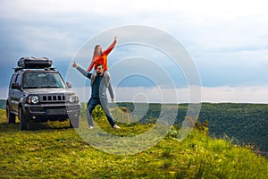 A couple in love fooling around, having fun, good mood on a trip, vacation. old SUV car, trip at warm summer day. Man and woman