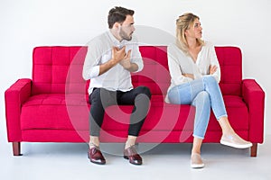 couple in love girlfriend and boyfriend having quarrel on red sofa at home, indoors . Upset