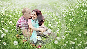 Couple in love guy and girl in a field of white daisies and green grass