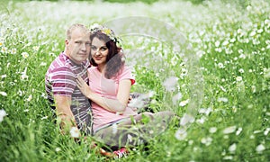 Couple in love guy and girl in a field of white daisies and green grass