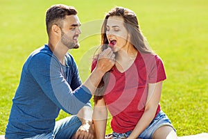 couple in love have fun in the park and drink smoothies and eating fruit at a picnic