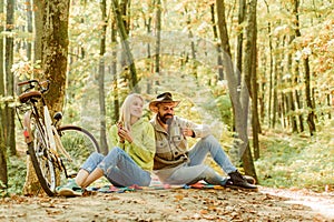 Couple in love having a picnic at fall autumn park. Bicycle ride by the autumnal road through fall forest. Hipster