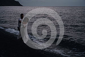 couple in love holding hands running along the beach by the sea