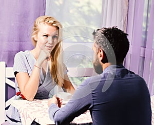 Couple in love holds cups of coffee at table. Woman and flirty face and man have an affair.