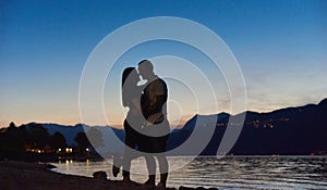 Couple in love hugging on the beach at night.