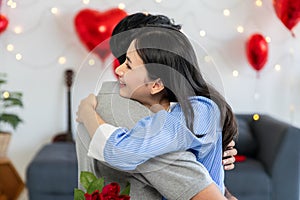 Couple in love hugging in the bedroom with rose and gift Valentine's Day concept