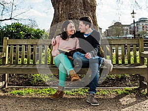 Couple in Love Hugging and Dating Sitting on a Bench in a Park