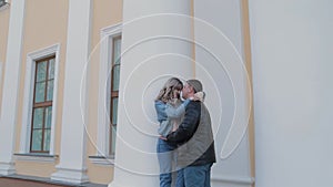 Couple in love hugs at the columns in the park.