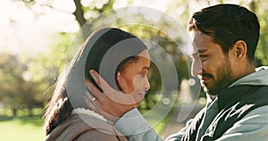 Couple, love and kiss outdoor at a park in nature with care and commitment in marriage. Face of a young man and woman