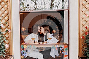 Couple in love kissing during date while sitting in bar and drinking wine