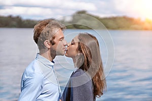 couple in love kissing standing on the shore of the lake .