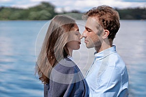 couple in love kissing standing on the shore of the lake .