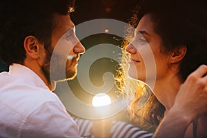 Couple in love looking at each other with sexual passion, affection, lit by lamp