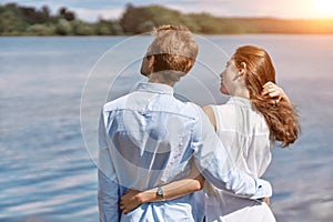 couple in love looking at a large lake .