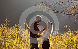 Couple in love looking one at each other in fields of reeds / Young couple looking in each other`s eyes with love in beautiful