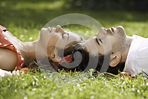 Couple in love lying on the grass in the park