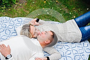 Couple in love lying on the plaid in the park