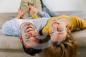 Couple in love lying on sofa at home - Boyfriend and girlfriend having fun together