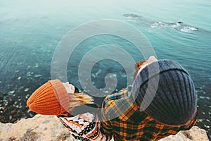 Couple in love Man and Woman together above sea on cliff looking up Traveling happy emotions Lifestyle concept. Young family at ro