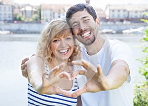 Couple in love outside showing heart with fingers