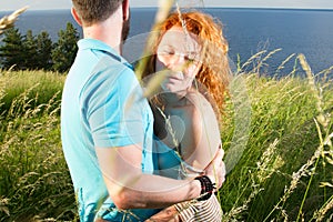 Couple in love passionately hugging. Long-awaited meeting of the two lovers outside near of lake. Red hair woman and man