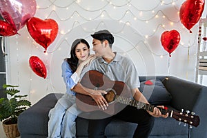 Couple of love playing on guitar for his cute lovely woman,Valentine's Day concept