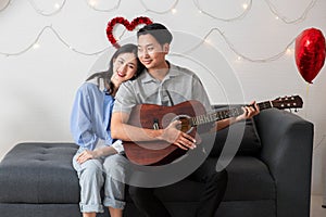 Couple of love playing on guitar for his cute lovely woman,Valentine's Day concept