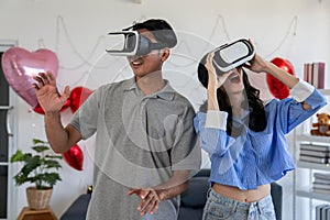 Couple of love playing video games together wearing VR glasses with fun in Valentine`s Day concept