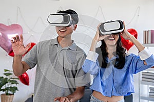 Couple of love playing video games together wearing VR glasses with fun in Valentine\'s Day concept