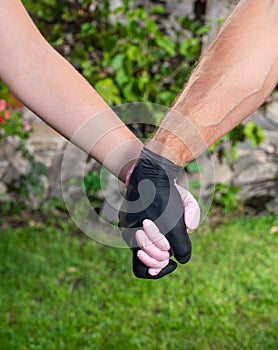 Couple in love in protective gloves holding hands