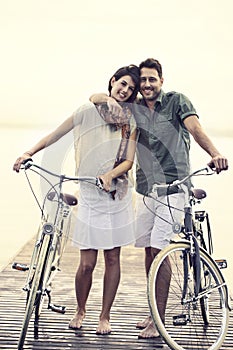 Couple in love pushing their bike together on a boardwalk