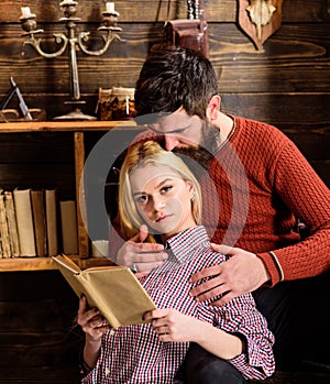 Couple in love reading poetry in warm atmosphere. Couple in wooden vintage interior enjoy poetry. Lady and man with