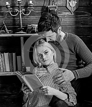 Couple in love reading poetry in warm atmosphere. Couple in wooden vintage interior enjoy poetry. Lady and man with