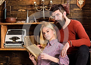 Couple in love reading poetry in warm atmosphere. Lady and man with beard on dreamy faces with book, reading romantic