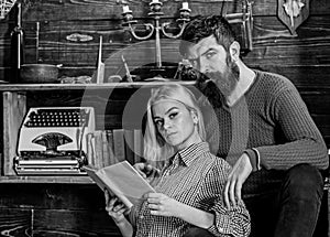 Couple in love reading poetry in warm atmosphere. Lady and man with beard on dreamy faces with book, reading romantic