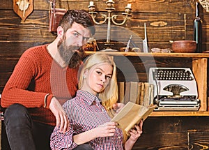 Couple in love reading poetry in warm atmosphere. Lady and man with beard on dreamy faces with book, reading romantic