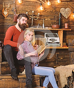 Couple in love reading poetry in warm atmosphere. Romantic evening concept. Couple in wooden vintage interior enjoy