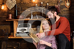 Couple in love reading poetry in warm atmosphere. Romantic evening concept. Lady and man with beard on dreamy faces with