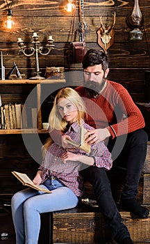 Couple in love reading poetry in warm atmosphere. Romantic evening concept. Lady and man with beard on dreamy faces hugs