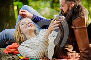 Couple in love relax in autumn forest with tea or coffee. happy woman and bearded man drink mulled wine. love date and